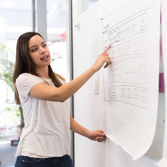 An Etho employee pointing to data on a large piece of paper